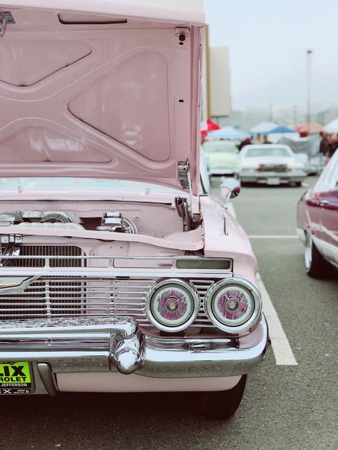 a pink car at a car show
