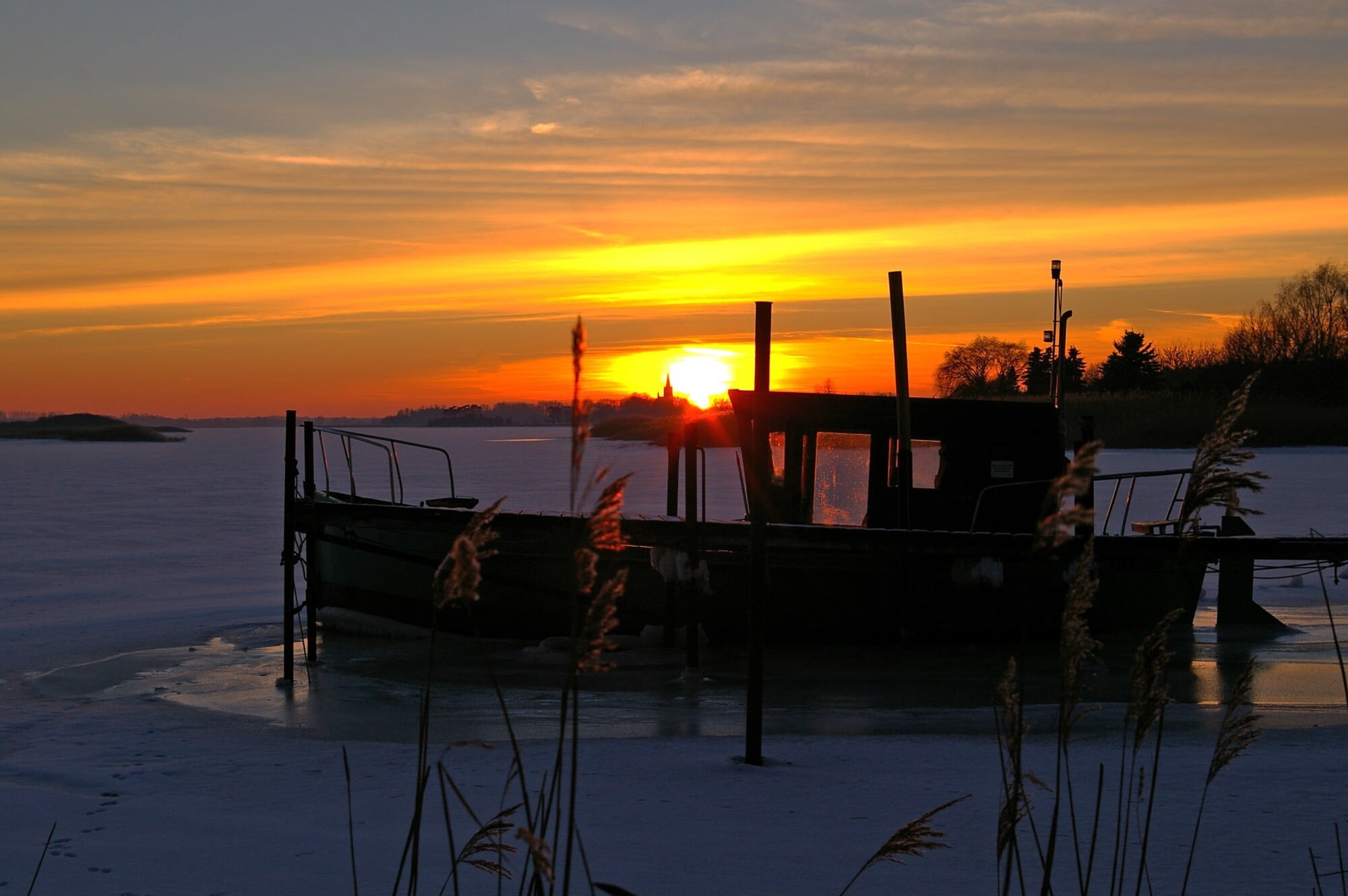 a boat on the river as the sun goes down